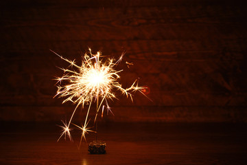 Holiday Bengal lights on the dark background. Burning sparkler, Happy New Year.