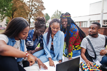 Group of five african college students spending time together on campus at university yard. Black...