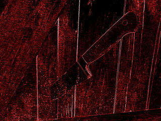 Nóz wbity w drewniane drzwi. © Patrycja