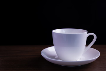 The coffee cup on the table has a black background