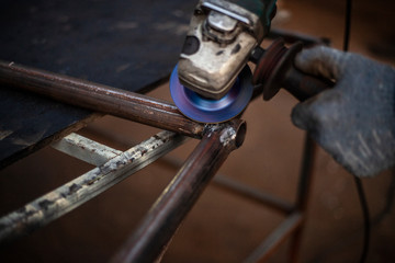 Cutting and grinding metal in the workshop. Work with a metal profile. Sparks from the work of a grinder for metal.
