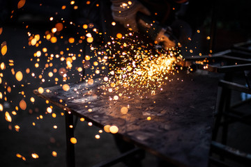 Cutting and grinding metal in the workshop. Work with a metal profile. Sparks from the work of a...