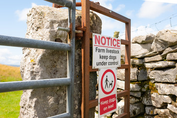 Detailed view of Warning signs at the entrance to a right of way in the Yorkshire Dales. Dog...
