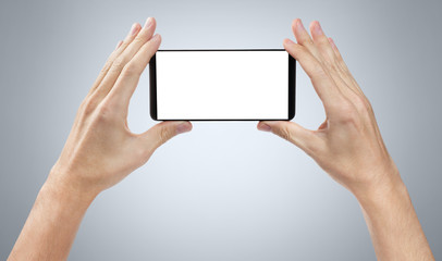 Hands with smartphone on gray background