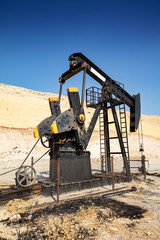 Oil drilling derricks at desert oilfield. Crude oil production from the ground. Oilfield services contractor. Oil drill rig and pump jack. Petroleum production, natural gas, liquids, NGL, additive.