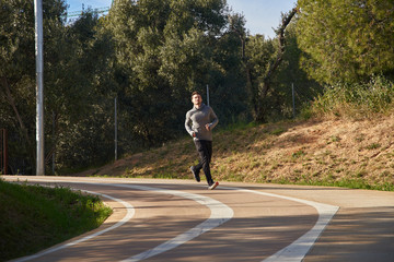 Man jogging on a road around a corner