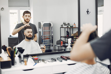 Man with a beard. Hairdresser with a client. Guy drinkig a whiskey