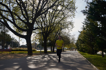 Fototapeta premium Man running on a tree lined road