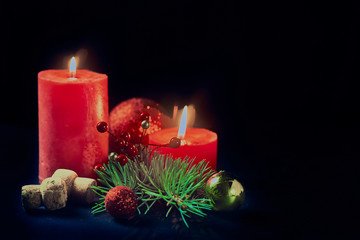 Christmas still life with two red candles and fir branches