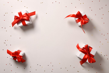 Background with four white Christmas gift boxes centered red bow