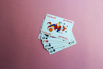 Cards for poker are in the middle of a pink background. Place for text.