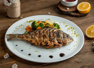 fried fish with vegetables in the plate __