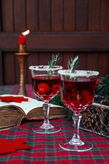 Christmas still life , two glass with red raspberry beverage decorated with rosemary , vintage old fashion style.