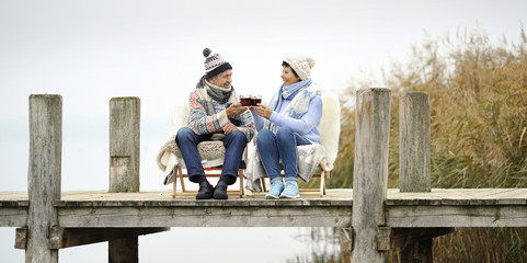 entspanntes Senioren Paar im Winter am Steg am See