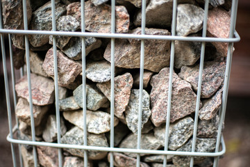 Stones inside a metal grill. Design element.