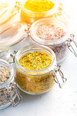 Four jars with different flavoured mixes of salt and spices. Himalayan and sea salt mixed with various peppers and herbs.