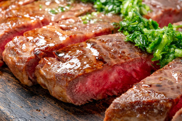 Roast sliced beef Steak medium rare Striploin with chimichurri sauce close up