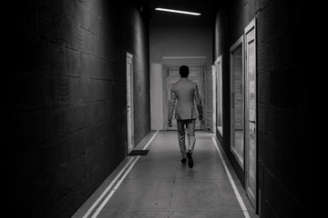 successful man walks down corridor chooses door