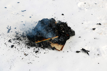 burning book in  snow. pages with the text in  open book burn with  bright flame.