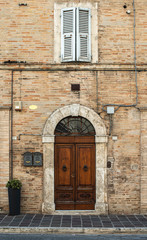 Fototapeta na wymiar Old typical italian wooden door. Round door arch.