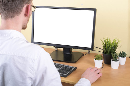 Office Worker At The Workplace At The Computer With Copy Space On The Monitor.Looking At Something On The Computer Screen