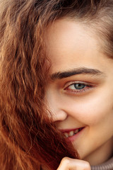 Fototapeta premium Beautiful young woman with curly hair. Portrait of a laughing girl