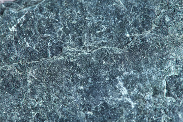 Grainy texture of greenish-gray natural stone. Natural backgrounds and textures. Decor and design. Horizontal.