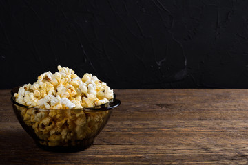 Air salty popcorn.A bowl of popcorn on a wooden table.Salt popcorn on the wooden background .  With space for text.Top view.popcorn texture.Chees .