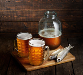 two mugs of beer and a can on a wooden background. Soviet style.