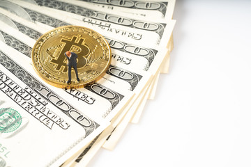 Miniature people business man standing on bitcoins coins.