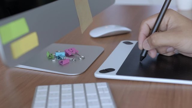Designer working  on graphic digital tablet , Hand of a man  drawing by electronic pen , Slow motion and Slider view.