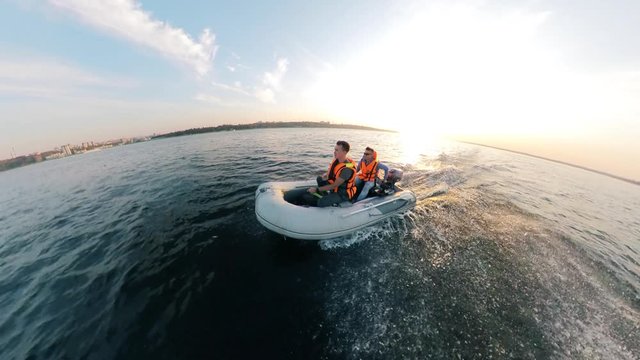 Two men in lifevests are driving an inflatable boat