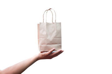 Brown paper bag on female hand isolated on white background. Mockup for design.