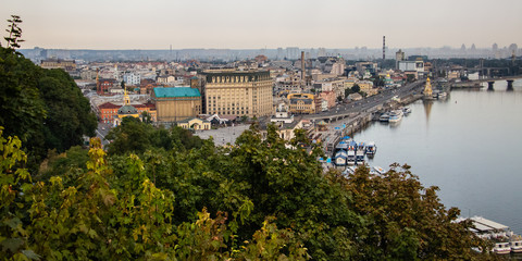 Fototapeta premium Tour of Kiev in the center of Europe. View of the Dnieper, Trukhanov island and a foot bridge. Park fountain and sunset on the horizon..