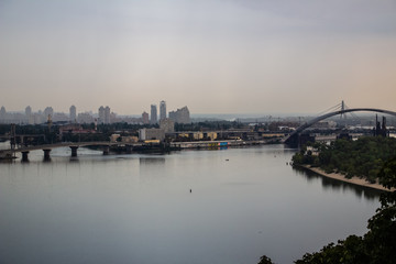 Tour of Kiev in the center of Europe. View of the Dnieper, Trukhanov island and a foot bridge. Park fountain and sunset on the horizon..