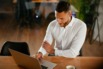 Young businessman using laptop in his office