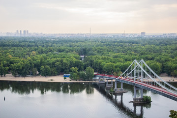 Tour of Kiev in the center of Europe. View of the Dnieper, Trukhanov island and a foot bridge. Park fountain and sunset on the horizon..