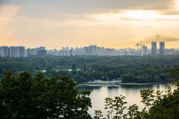 Fototapeta premium Tour of Kiev in the center of Europe. View of the Dnieper, Trukhanov island and a foot bridge. Park fountain and sunset on the horizon..