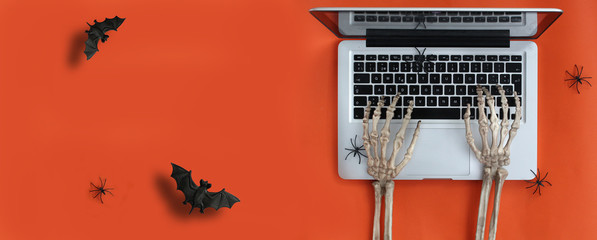 Skeleton hands typing on laptop