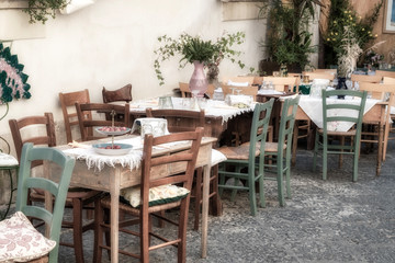 Fototapeta na wymiar View of a restaurant outdoors tables, in the city centre of Ortigia (Italy, Sicily, Siracusa), UNESCO World Heritage Site.