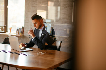 Young businessman using laptop in his office