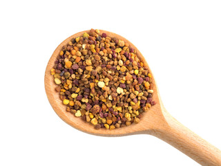 Top view of the wooden spoon of bee pollen isolated on white