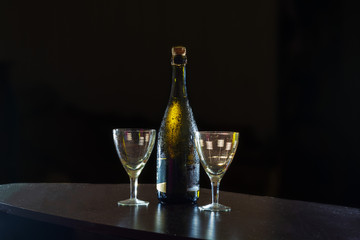Pouring champagne wine into glasses over black background. Celebration concept