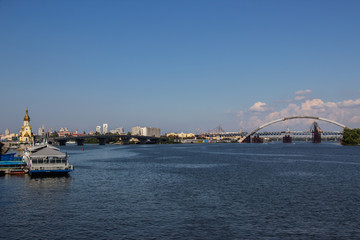 Obraz premium Tour of Kiev in the center of Europe. View of the Dnieper, Trukhanov island and a foot bridge. Park fountain and sunset on the horizon..