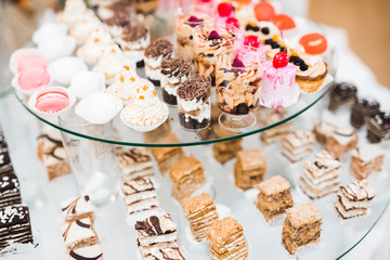 Delicious and tasty dessert table with cupcakes shots at reception closeup