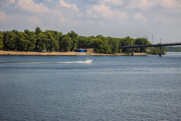 Obraz premium Tour of Kiev in the center of Europe. View of the Dnieper, Trukhanov island and a foot bridge. Park fountain and sunset on the horizon..