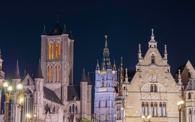 Buildings in the Graslei, quay in the promenade next to river Lys in Ghent, Belgium and St Michael's Bridge at dusk. Gent old town is famous for its illuminated buildings at night. 