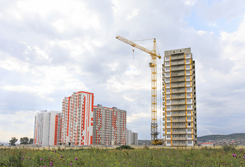 Fototapeta na wymiar high-rise building construction. Construction crane against the sky. City under construction in the mountains