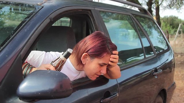 drunk girl vomiting out of car window synonymous with stress and car sickness