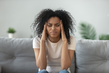 Exhausted black woman massage head suffering from migraine